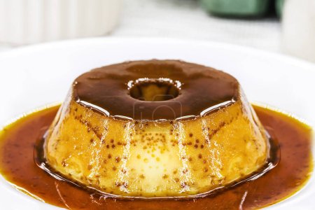 Téléchargez les photos : Small condensed milk pudding, with ingredients in the background, eggs, sugar, cinnamon, caramel and condensed milk, Homemade sweet recipe. - en image libre de droit