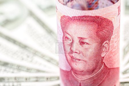 Chinesischer Geldschein, 100-Yuan-Schein, umgeben von vielen Hundert-Dollar-Scheinen. Konzept der Finanzkrise zwischen den USA und China