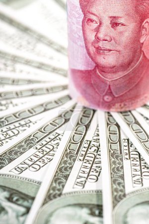 Chinesischer Geldschein, 100-Yuan-Schein, umgeben von vielen Hundert-Dollar-Scheinen. Konzept der Finanzkrise zwischen den USA und China