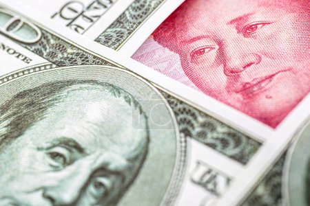 billete de yuan, rodeado de billetes de 100 dólares. Concepto de proteccionismo del mercado americano