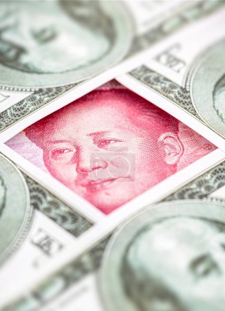 yuan banknote, surrounded by 100 dollar bills. American market protectionism concept