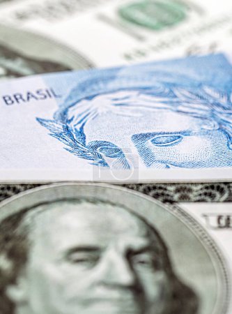 one hundred Brazilian banknotes and one hundred American dollars banknotes, concept of Brazilian economy in crisis, devaluation of the Brazilian real.