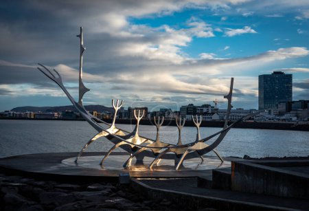 Téléchargez les photos : Reykjavik, Islande - 10 novembre 2022 : The Sun Voyager, une sculpture en acier d'un navire long viking de Jon Gunnar Arnarson sur le front de mer de Reykjavik. Jour ensoleillé, ciel bleu. - en image libre de droit