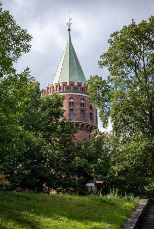 Téléchargez les photos : Stargard Szczecinski, Pologne - 12 septembre 2021 : Un château d'eau néogothique en brique rouge, entouré d'un parc. - en image libre de droit