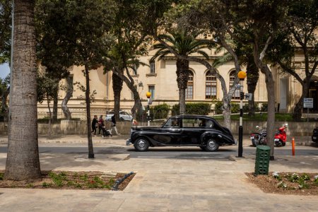 Photo for Valletta, Malta - April 16, 2023: A black diplomatic limousine driving a street in Floriana. - Royalty Free Image