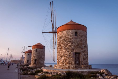 Photo for Rhodes, Greece - May 27, 2023: The windmills of Mandraki at sunset. - Royalty Free Image