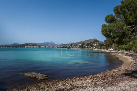 Port de Pollenca, Mallorca, Balearen, Spanien. Schöner kleiner felsiger Strand, türkisfarbenes Mittelmeer, blauer Himmel. 