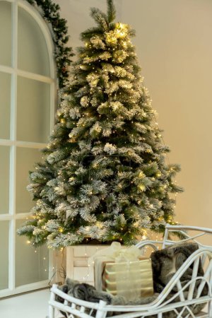 Photo for Christmas tree in lights. There is a sledge with a gift in front of it. New Year, Christmas, holidays. Selective focus, defocus - Royalty Free Image