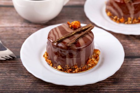 Frische köstliche Schokolade Souffleuse Kuchen auf weißem Teller auf hölzernem Hintergrund Nahaufnahme. Karamellglasur und Dekoration verleihen Reiz und Lust