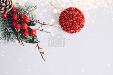 Silvester, Weihnachtsdekor rot-grün auf weißem Hintergrund in gelbem Licht. Flache Lage