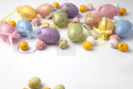 Foto de Multi-colored decorative eggs on a white background. Happy Easter background. Top view - Imagen libre de derechos