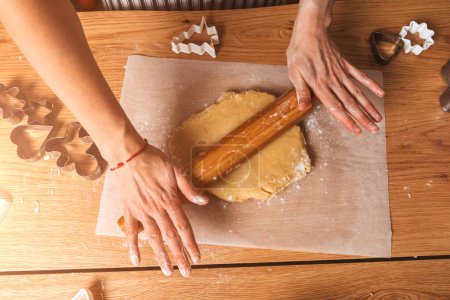 Foto de Primer plano de las manos de las mujeres extender la masa en las galletas. Cocinar postres en casa. Vista superior - Imagen libre de derechos