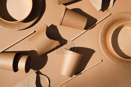 Téléchargez les photos : A set of paper utensils and on a brown background. Eco friendly, zero waste concept. Top view - en image libre de droit