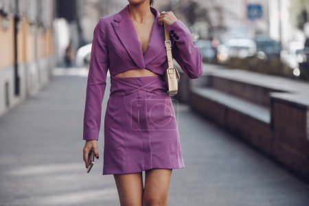 Téléchargez les photos : Milan, Italy - February 25, 2022: Crop anonymous female in purple outfit with high heels walking on street. - en image libre de droit