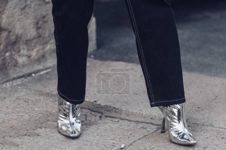 Photo for Milan, Italy - February 24, 2022: Woman wearing dark jeans and silver glitter pointy toe stiletto heeled boots. - Royalty Free Image