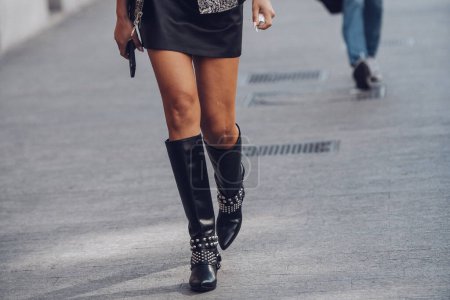 Foto de Milan, Italy - February 25, 2022: Female wearing black leather skirt and black boots white silver ornaments. - Imagen libre de derechos