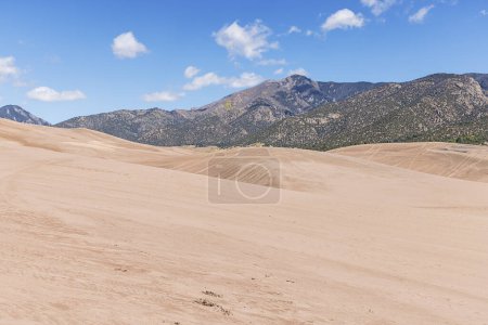 Photo for Hiking in the middle of the Great Sand Dunes with the Rocky Mountains in a distance - Royalty Free Image