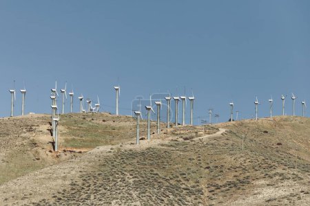 Foto de Experimente la intersección de la grandeza natural y la innovación tecnológica con esta fotografía de alta resolución de turbinas de molino de viento dispersas en el paso Tehachapi del desierto de Mojave, sureste - Imagen libre de derechos