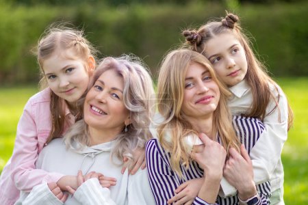 Happy family outdoors: mother, grandmother, and daughter