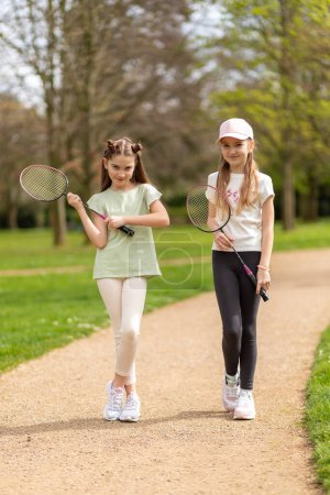 Photo for Two girls with badminton rackets on a park path - Royalty Free Image
