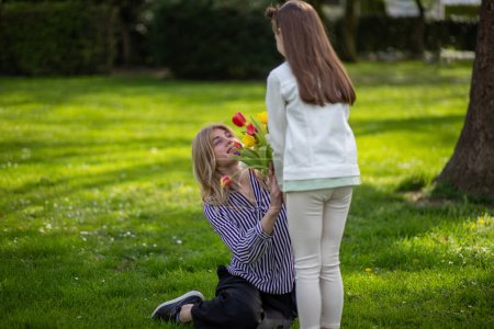 Hija regalando tulipanes madre. Celebración familiar, amor y aprecio