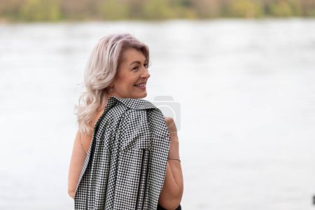 Mature woman turned around by the river.