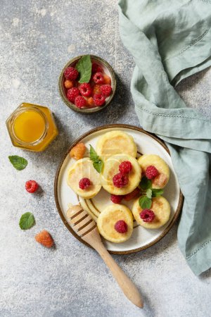 Photo for Homemade cottage cheese pancakes gluten free (syrniki, curd fritters) with berries on a stone background. Ricotta pancakes, morning breakfast table. View from above. - Royalty Free Image