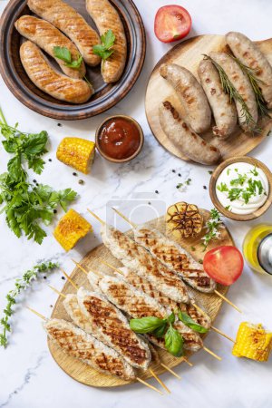 Photo for Grill food menu. Various bbq grilled sausages with fresh herbs and spices on marble tabletop. Summer party food. - Royalty Free Image