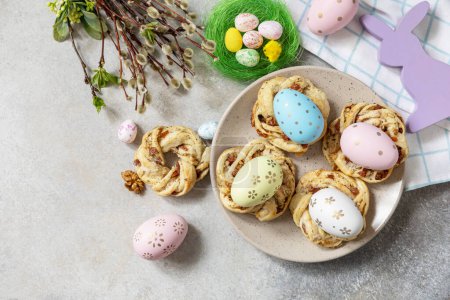 Foto de Easter composition. Sweet Italian Easter Bread Rings from puff pastry and dyed eggs on a stone background. View from above. Copy space. - Imagen libre de derechos