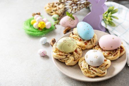 Foto de Easter composition. Sweet Italian Easter Bread Rings from puff pastry and dyed eggs on a stone background. Copy space. - Imagen libre de derechos