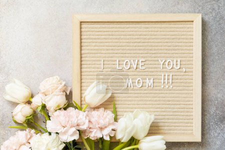 Photo for Happy Mother's Day. Letter I LOVE MOM on letterboard and beautiful spring flowers on light background. Womans day, wedding, mothers day greeting card. View from above. - Royalty Free Image