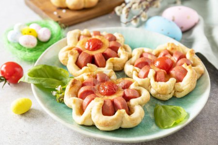 Photo for Idea for Easter breakfast or lunch. Mini pizza. Pizza in puff pastry with cheese and tomatoes on the festive table. - Royalty Free Image