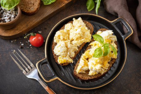 Photo for Scrambled eggs on whole grain bread. Homemade breakfast or brunch meal - scrambled eggs. - Royalty Free Image