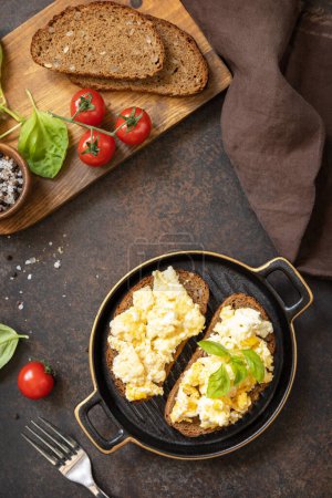 Foto de Huevos revueltos en pan integral. Desayuno casero o almuerzo - huevos revueltos. Vista desde arriba. - Imagen libre de derechos