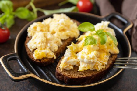Téléchargez les photos : Œufs brouillés sur pain de grains entiers. Petit déjeuner ou brunch maison - œufs brouillés. - en image libre de droit