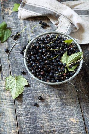 Photo for Raw organic berries. The concept of vitamin c food. Fresh black currants on a wooden table in rustic style. Copy space. - Royalty Free Image