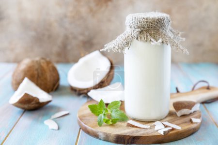 Photo for Vegan non dairy alternative milk, health content. Organic coconut milk in a bottle on a rustic table. - Royalty Free Image