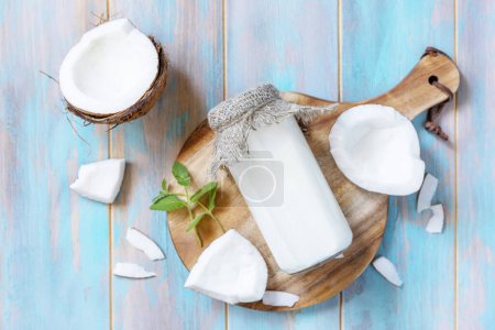 Photo for Vegan non dairy alternative milk, health content. Organic coconut milk in a bottle on a rustic table. View from above. - Royalty Free Image