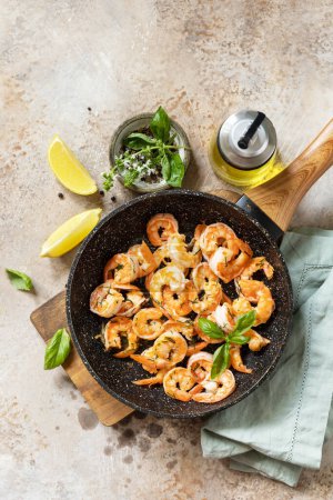 Photo for Spicy garlic chili Shrimps boiled shrimps and herbs, prawns in a frying pan with lemon. Seafood, shellfish. View from above. - Royalty Free Image