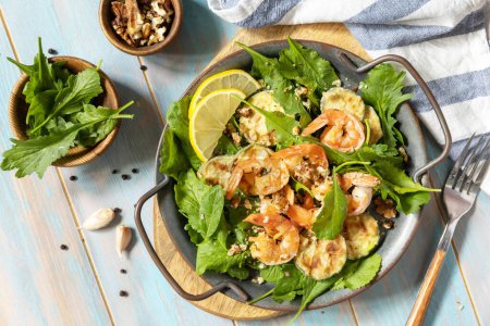 Photo for Healthy food concept. Diet summer salad plate. Shrimps salad with arugula, grilled zucchini and walnut. Top view. - Royalty Free Image