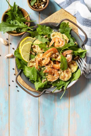 Photo for Healthy food concept. Diet summer salad plate. Shrimps salad with arugula, grilled zucchini and walnut. View from above. Copy space. - Royalty Free Image