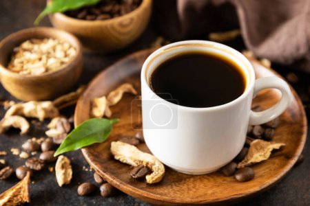 Mushroom coffee in a cup and coffee beans, trendy drink on a stone background. Healthy organic energizing adaptogen. 