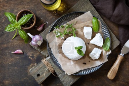 Photo for Homemade Italian ricotta cheese or cottage cheese with basil on a rustic table. Vegetarian healthy diet, fermentation food concept. View from above. - Royalty Free Image