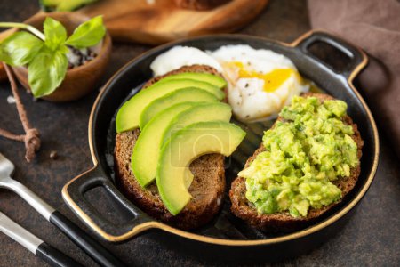 Photo for Healthy breakfast concept, sandwich with avocado and egg. Wholemeal bread toast sliced avocado and poached egg on a stone background. - Royalty Free Image