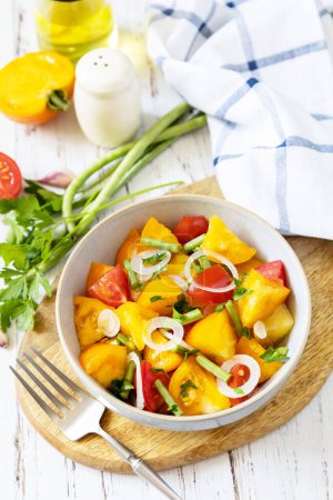 Téléchargez les photos : Le concept d'aliments végétaliens ou diététiques. Salade de tomates composée d'un mélange de tomates rouges et jaunes et de haricots verts sur une table en bois. - en image libre de droit