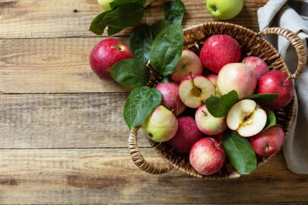 Photo for Fall harvest background. Organic fruits. Farmer's market. Basket of ripe apples on a rustic wooden table. View from above. Copy space. - Royalty Free Image