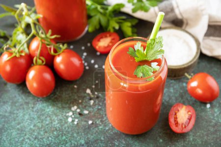 Photo for Autumn vitamin drink juice tomato. Tomato juice in a glass and fresh tomatoes on a stone tabetop. Copy space. - Royalty Free Image