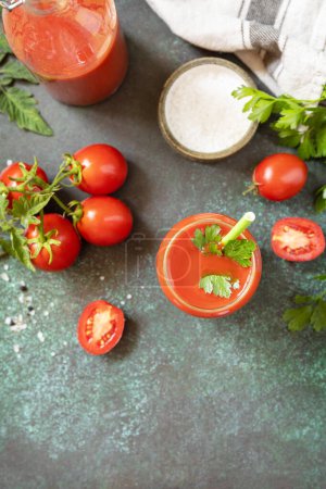Photo for Autumn vitamin drink juice tomato. Tomato juice in a glass and fresh tomatoes on a stone tabetop. View from above. Copy space. - Royalty Free Image