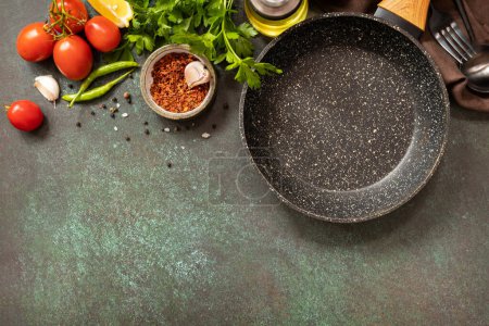 Photo for Food cooking background with Frying pan. Empty skillet, vegetables, spices and herbs on dark table background. View from above. Copy space. - Royalty Free Image