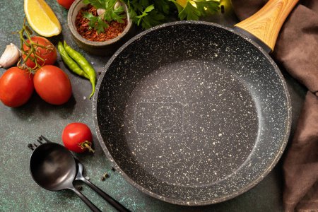 Photo for Food cooking background with Frying pan. Empty skillet, vegetables, spices and herbs on dark table background. - Royalty Free Image